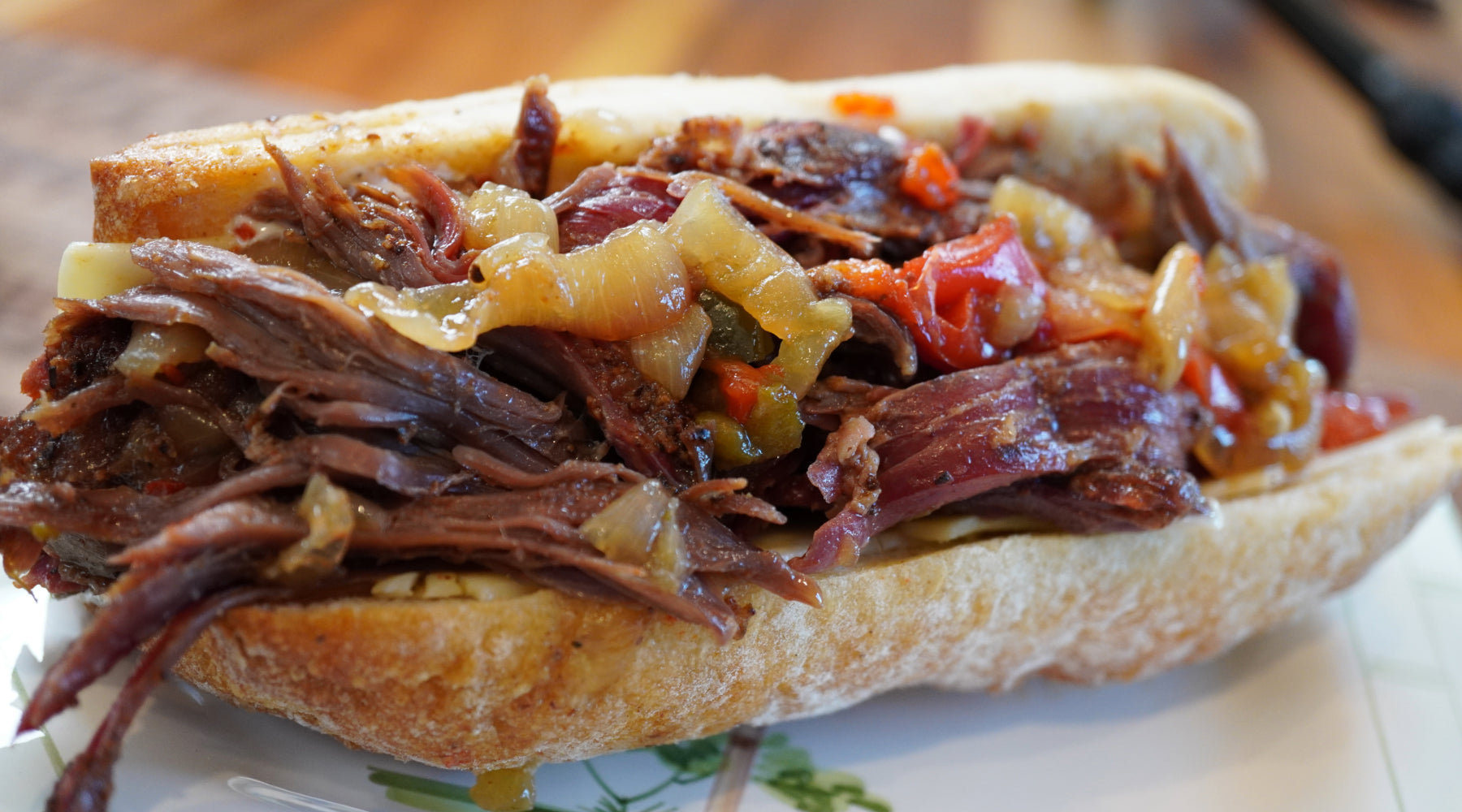 Sandwich filled with smoked and braised Thor’s Hammer beef shank, melted cheese, onions, and peppers on a crusty roll.