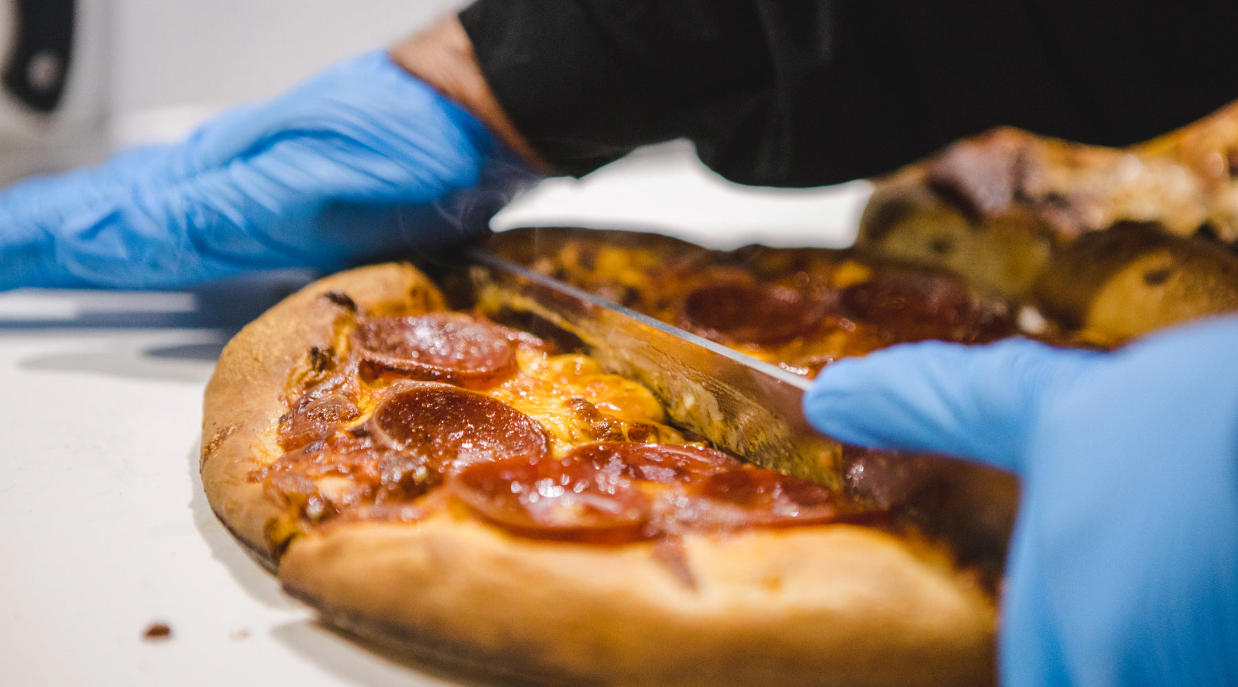 Cutting a pepperoni pizza