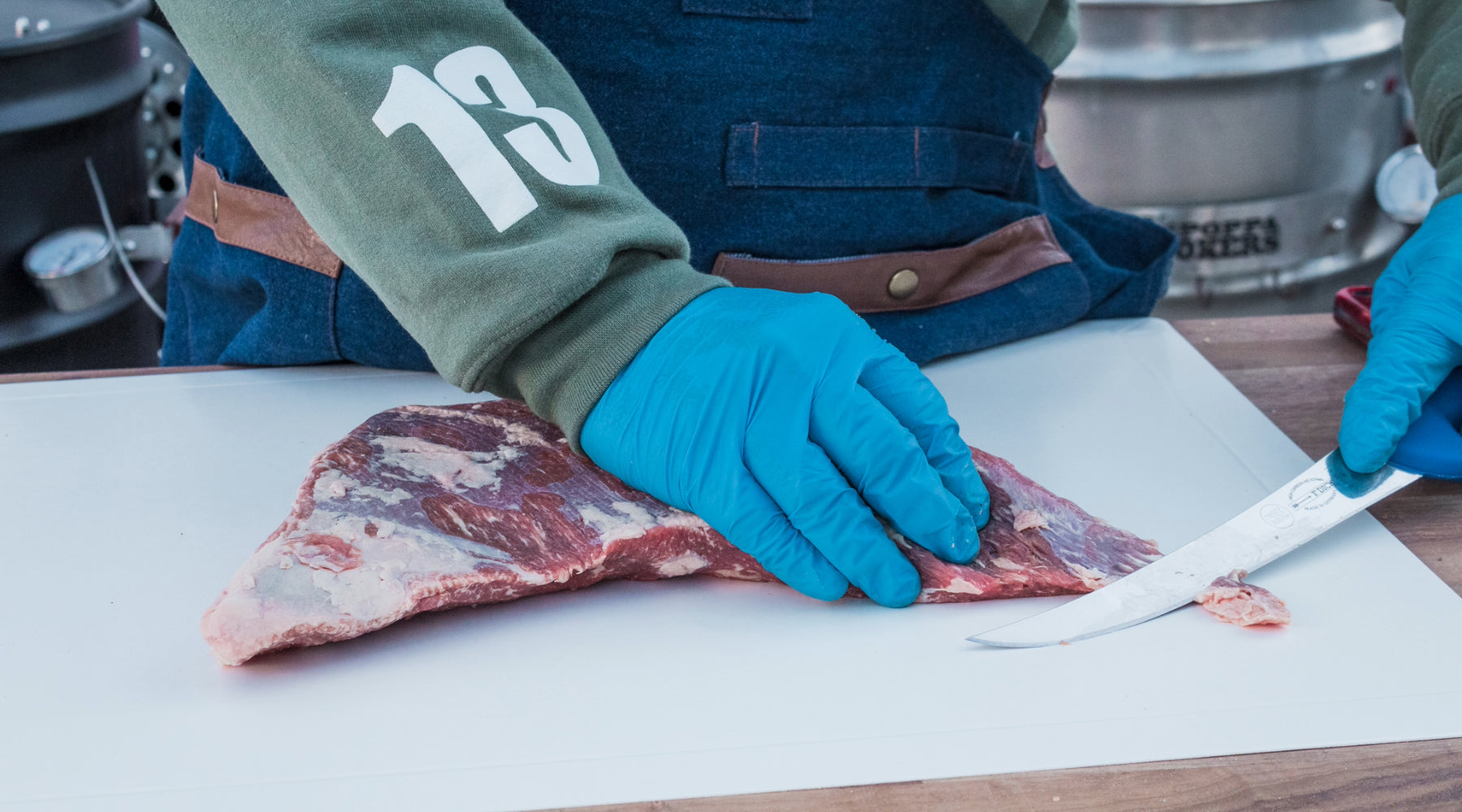 Trimming meat with bbq gloves on your hands for food safety
