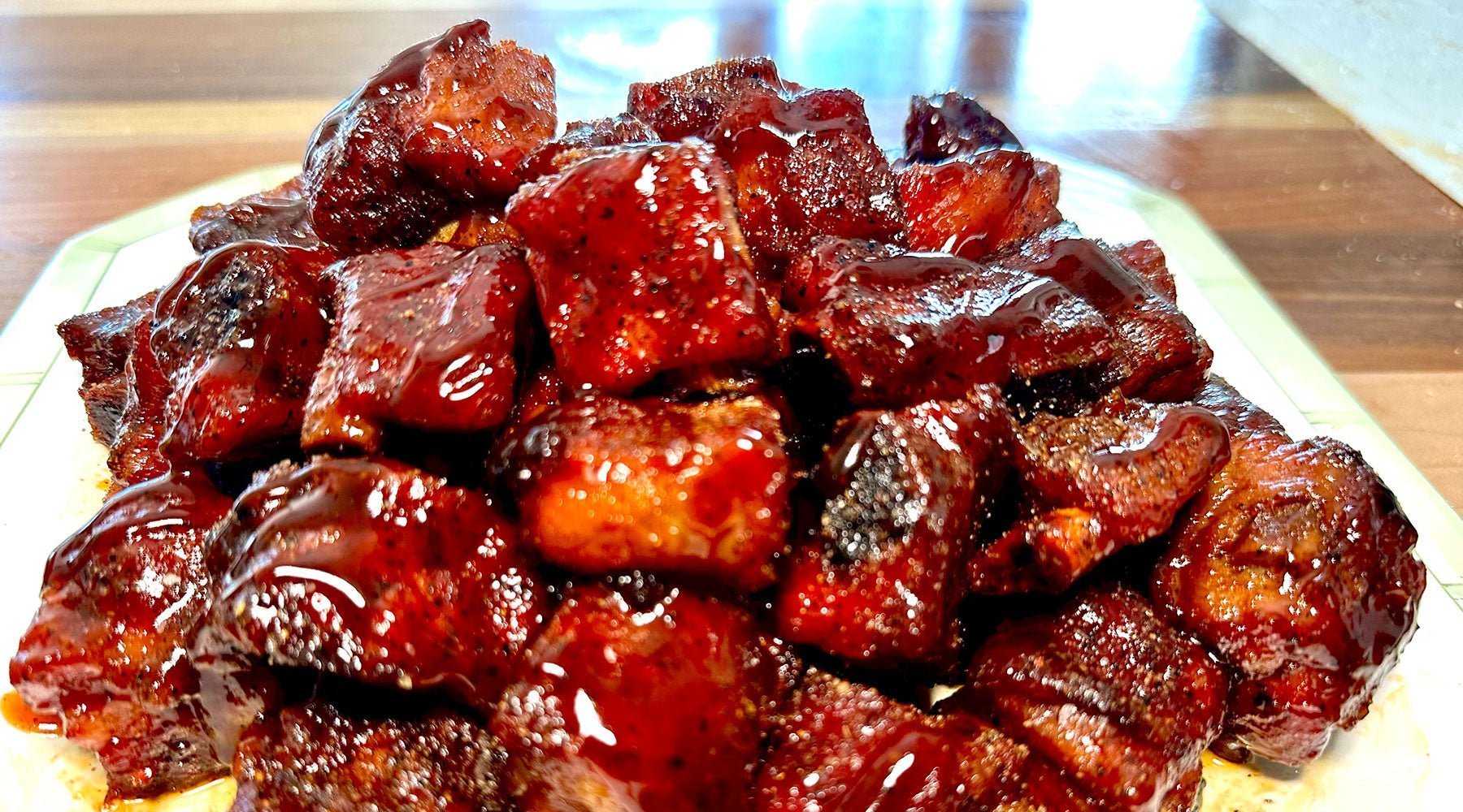 Saucy barbecued pork rib snacks on a plate, glazed in BBQ sauce with crispy edges & tender, juicy texture on display