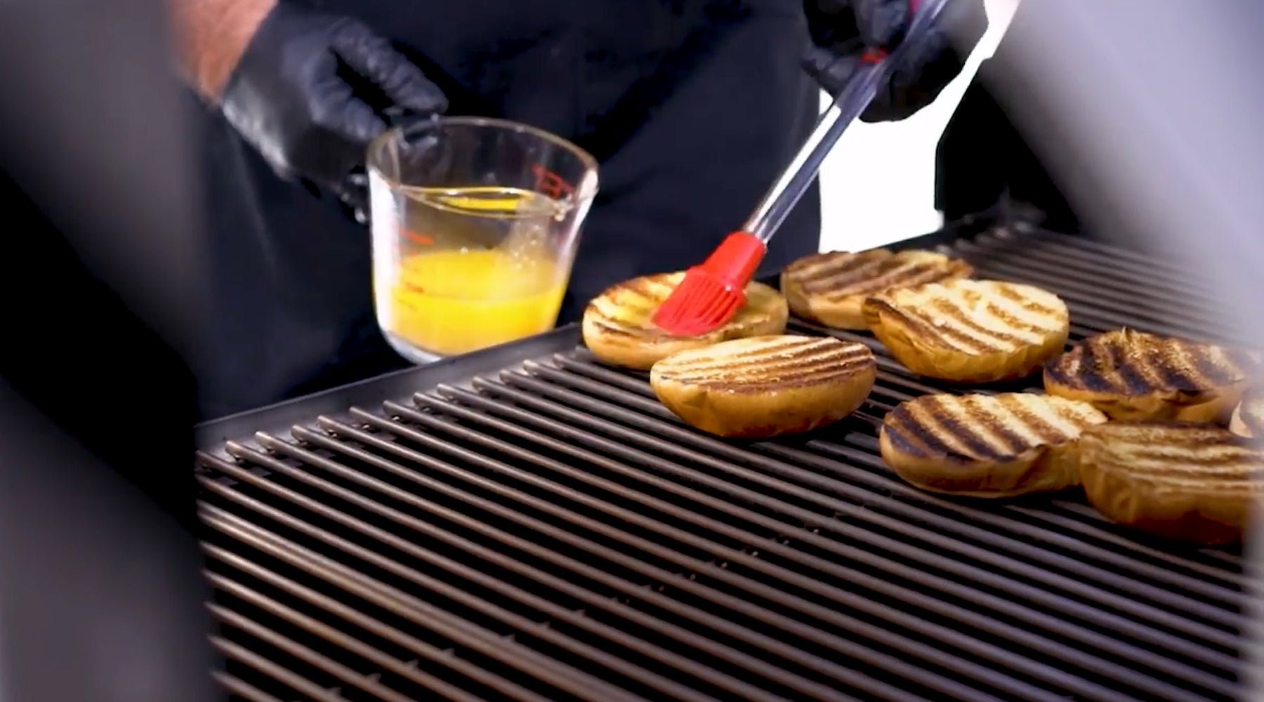 Brushing the buns with butter while on the grill.