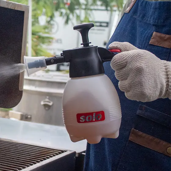Big Poppa at the grill spraying his brisket using his Solo Hand Sprayer to keep the meat moist.