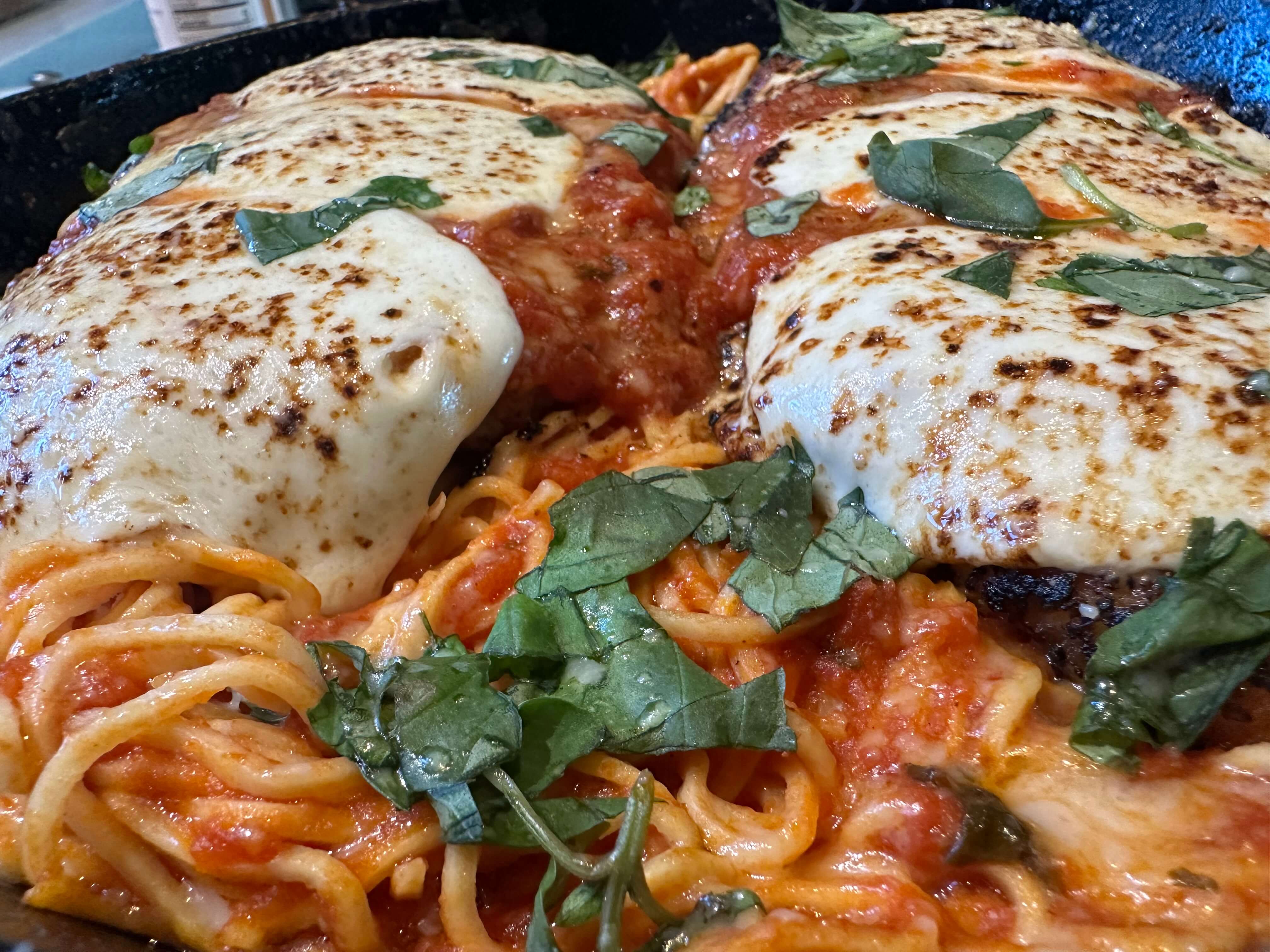 Spaghetti with meat sauce and melted cheese on a plate