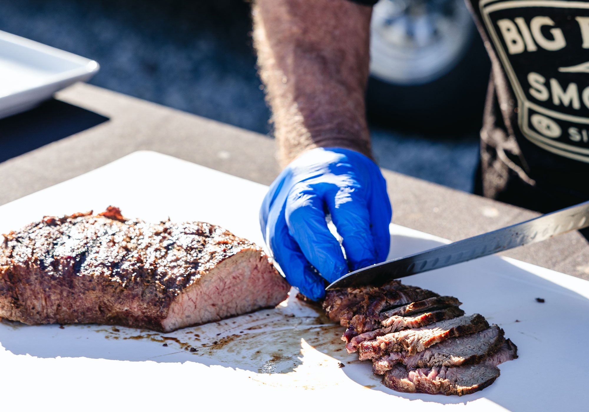Big Poppa is slicing a tri-tip as he prepares to make sandwiches.