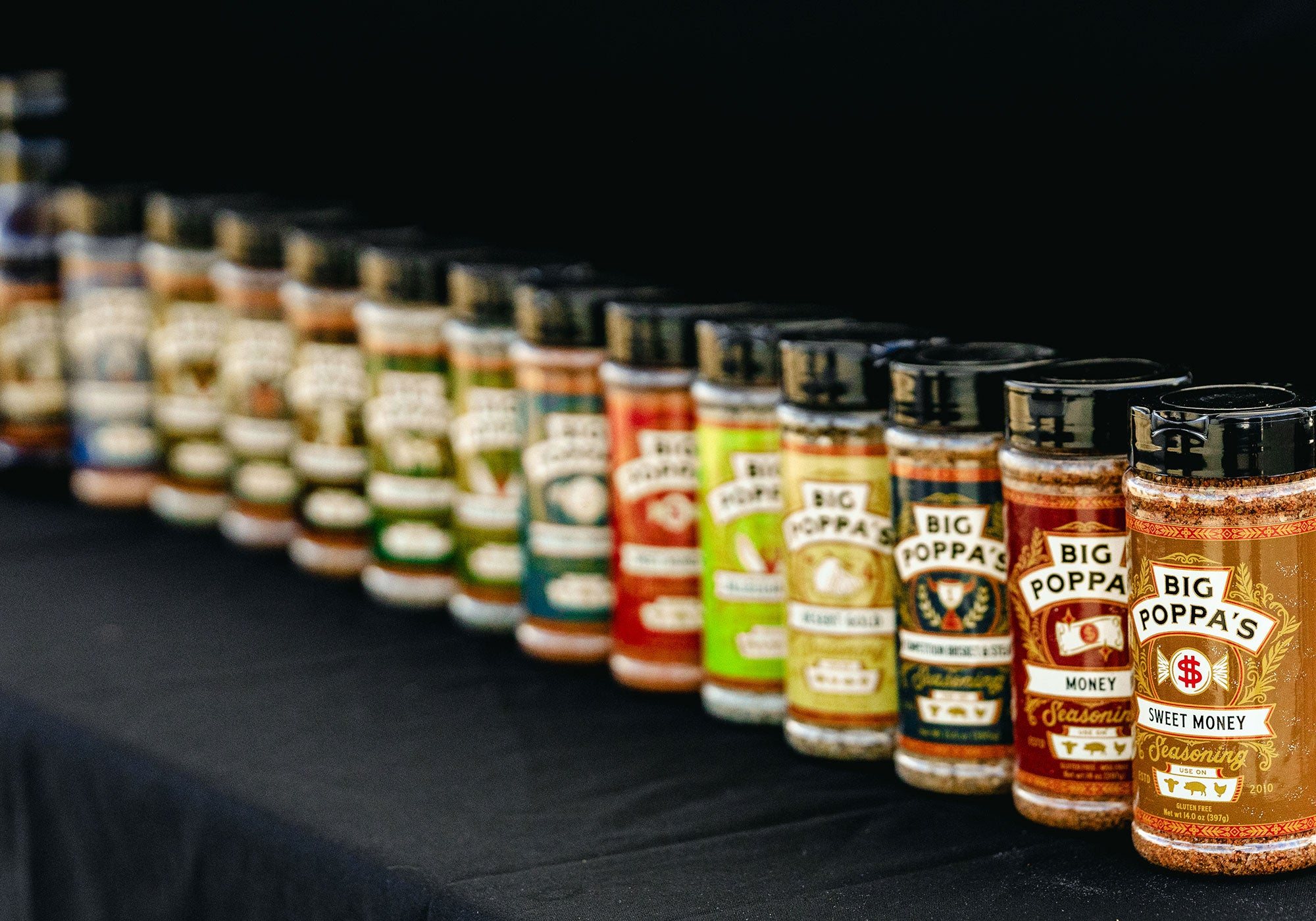 Feature of all of the Big Poppa Smokers product lined up in a row on a black backdroup.