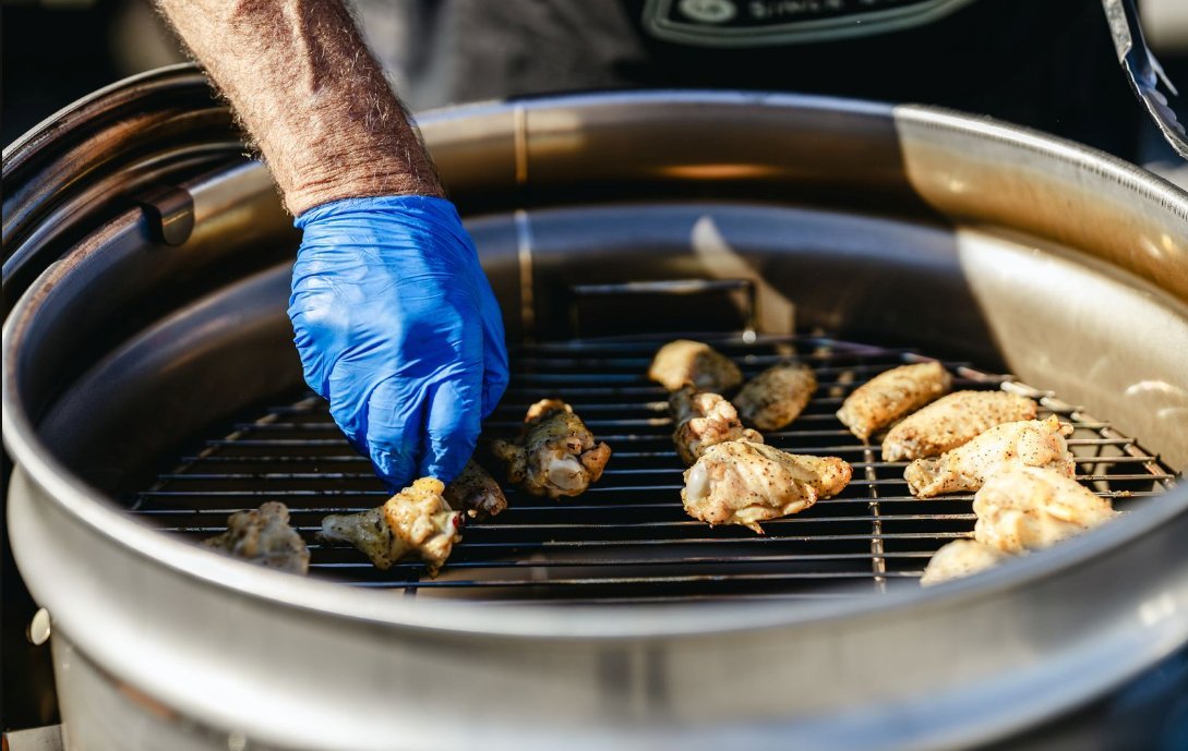 Beefy stainless steel grate on drum smoker as Big Poppa is preparing wings for the big game.