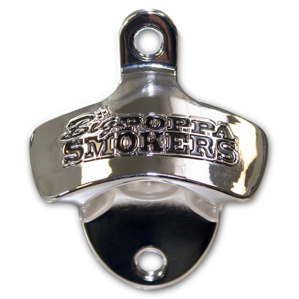 Close-up of a shiny stainless steel bottle opener embossed with the 'Big Poppa Smokers' logo. The opener has a classic top-pull design, featuring a curved handle with a circular hole for hanging and a black, concave base for cap removal, set against a black background.
