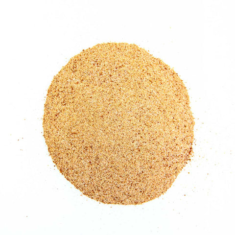 Close-up view of light brown finely ground seasoning powder, uniformly spread over a white background, showing a mix of spices suitable for beef preparation.