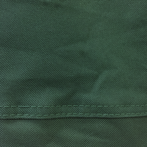 Detailed close-up of the textured green fabric used for a drum smoker cover, highlighting the weave and stitching details.