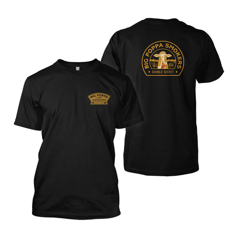 Front view of a black T-shirt with a small logo on the left chest that reads 'Big Poppa Smokers' in gold and white text, featuring an illustration of a cow.