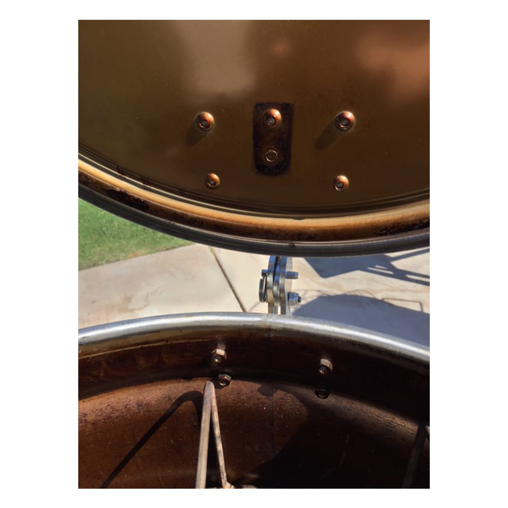 Close-up of Unknown BBQ Drum Smoker Lid Hinge on a 55-gallon drum smoker, showcasing its sturdy stainless steel construction and precise installation. Close up is from inside of the drum with the lid open.