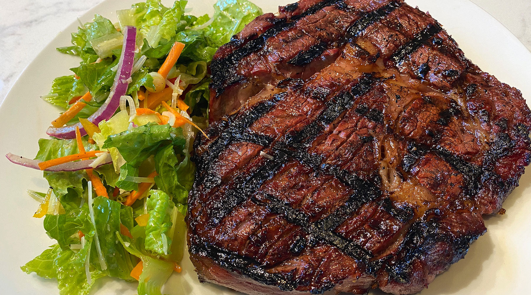 Perfectly seasoned and seared steak with Big Poppa's Double Secret seasoning with a classic side salad.