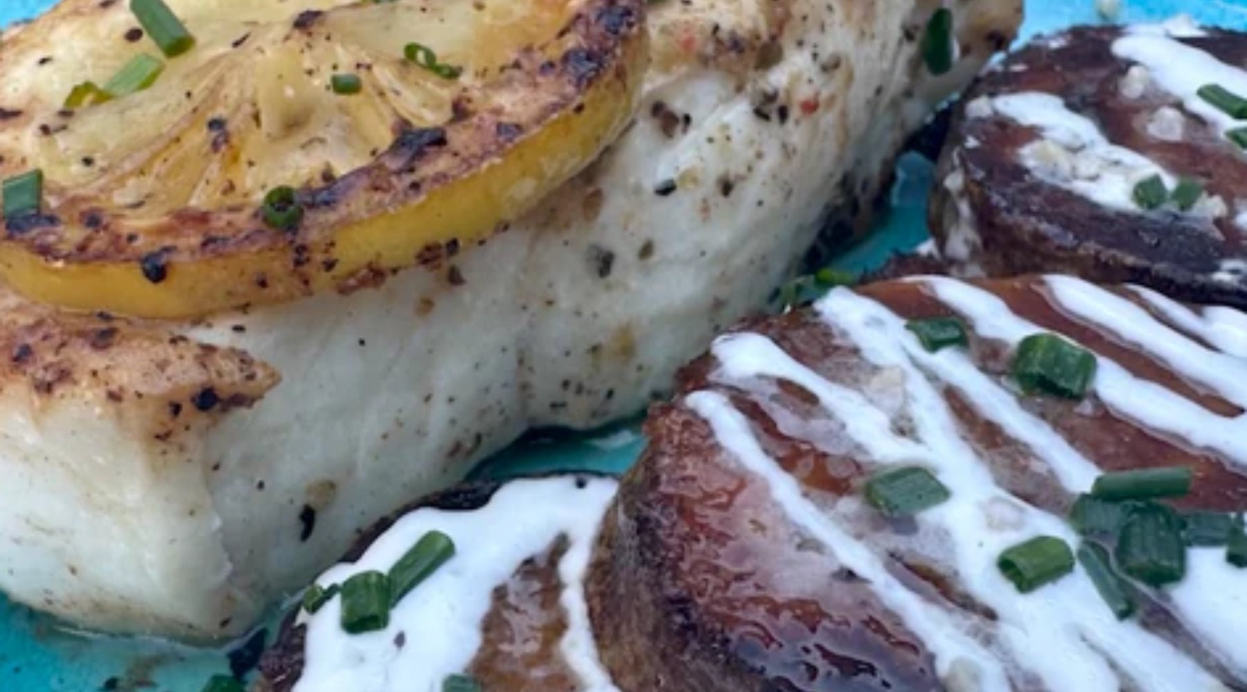 Upclose image of the dinner that features grilled halibut with Desert Gold and parmesan crusted potatoes.