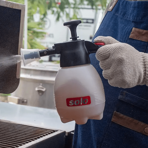 Big Poppa at the grill spraying his brisket using his Solo Hand Sprayer to keep the meat moist.