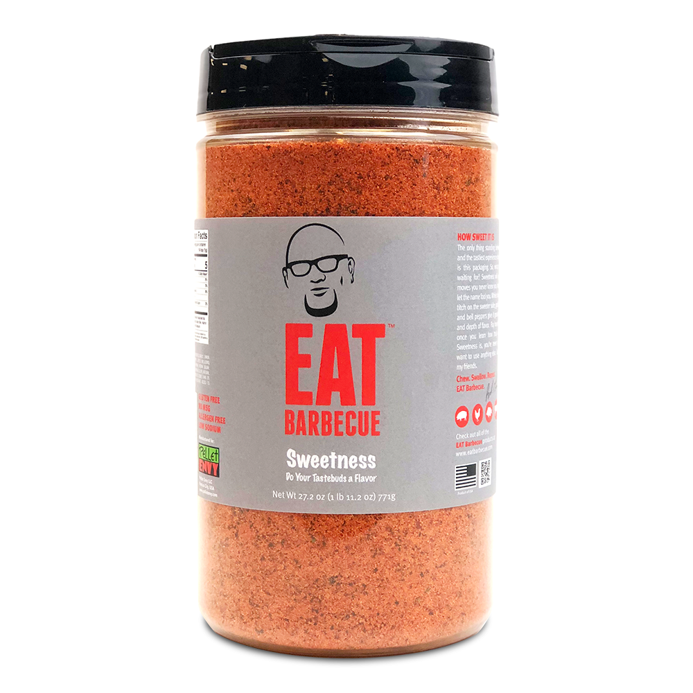 A large container of Eat Barbecue Sweetness Rub with a gray label, black lid, and a net weight of 27.2 oz (771g). The label features a caricature of a man with glasses and the text 'EAT Barbecue Sweetness, Do Your Tastebuds a Flavor.'nces (187 grams).