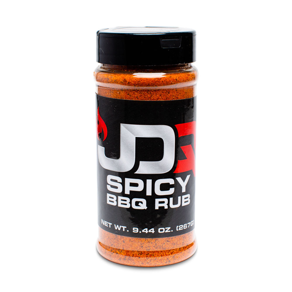 The front of a JDQ Spicy BBQ Rub container with a black label featuring bold white and red text. The label reads "JDQ Spicy BBQ Rub" with a net weight of 9.44 oz (267g). The container is filled with a vibrant orange spice blend.