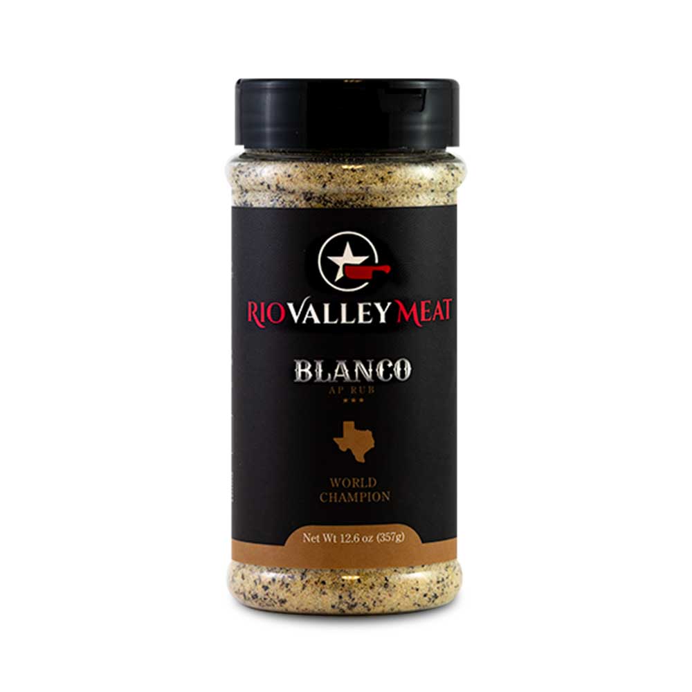 A jar of Rio Valley Meat Blanco AP Rub, featuring a black label with red and white text, displaying the product name, 'World Champion' title, and a Texas state silhouette. The jar is filled with a coarse blend of spices.