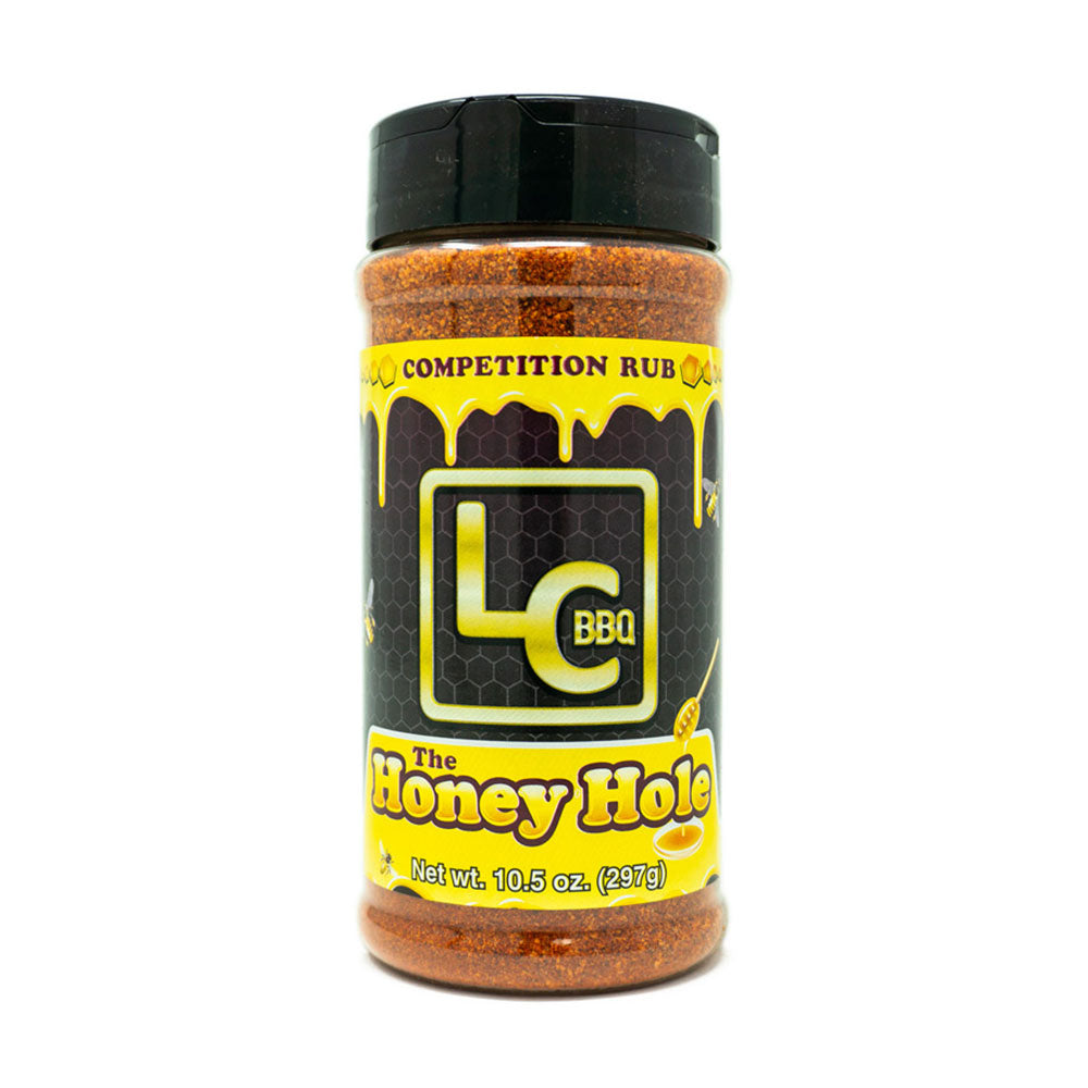 A bottle of LC BBQ The Honey Hole Competition Rub viewed from the front. The label features a honeycomb background with the LC BBQ logo and the text "Competition Rub" at the top. The product name "The Honey Hole" is displayed in a yellow banner at the bottom. The label indicates that the bottle contains 10.5 ounces (297 grams) of seasoning.