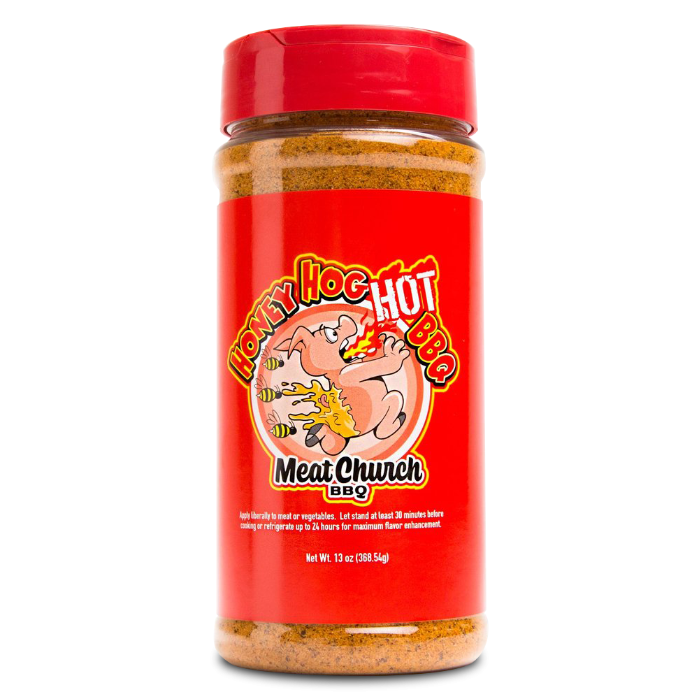 A 13-ounce jar of Meat Church Honey Hog Hot BBQ Rub. The label is red with yellow and white text, featuring a cartoon pig breathing fire, surrounded by bees. The jar has a red lid and contains a coarse, reddish-brown spice mix.