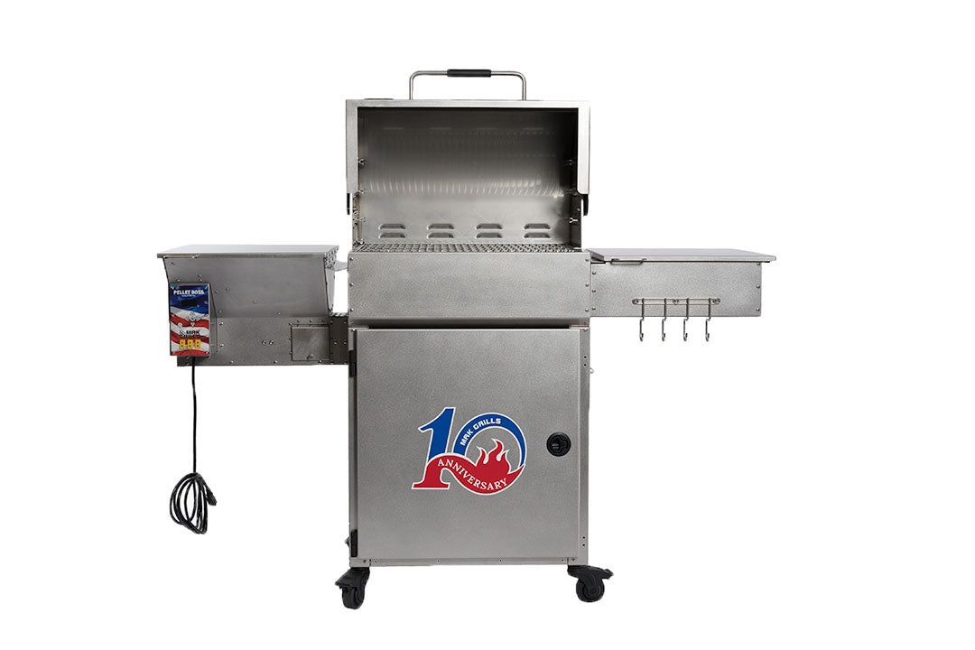 A stainless steel grill with the lid open, revealing the cooking grates inside. The grill features side shelves, a "10th Anniversary" logo on the front, and hooks for utensils on the right. An electrical cord is visible on the left side.