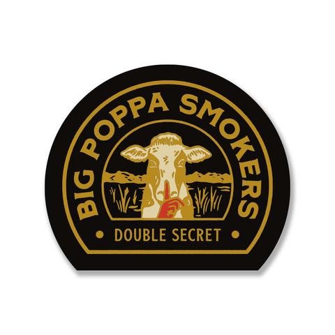 Oval sticker with a black background and gold trim. It features a graphic of a cow in the center with the text 'Big Poppa Smokers - Double Secret' surrounding the cow. The design is detailed in gold and white colors.