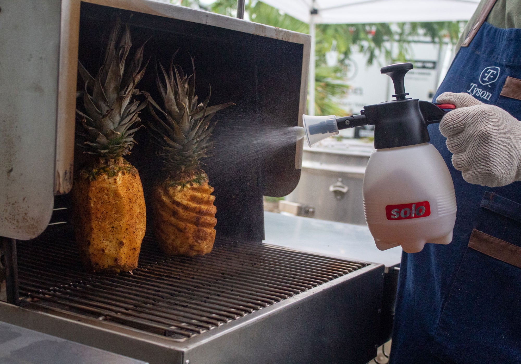 Big Poppa using his Solo Hand Sprayer to add moisture to his grilled pineapple he is cooking.