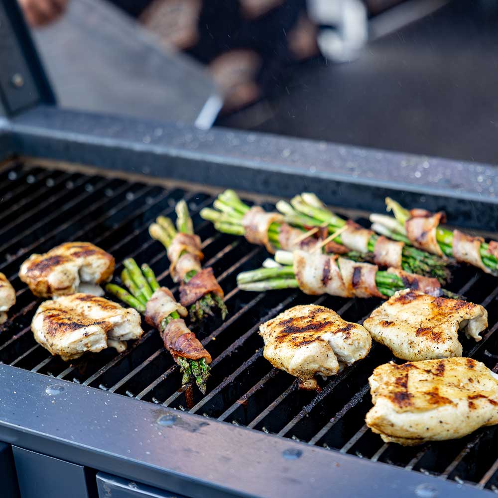 chicken and bacon wrapped asparagus cooking on a grill, showcasing perfect sear marks and a juicy texture