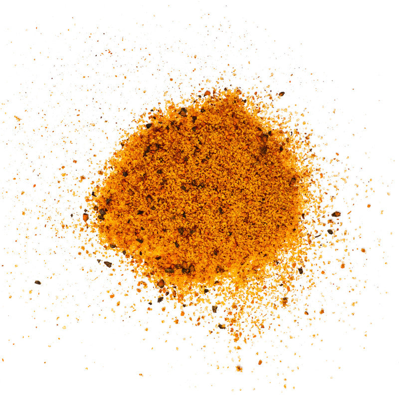 A close-up view of a pile of Man Meat BBQ Kansas City Style Rub. The spice mix is a coarse, reddish-brown powder with visible black pepper flakes.