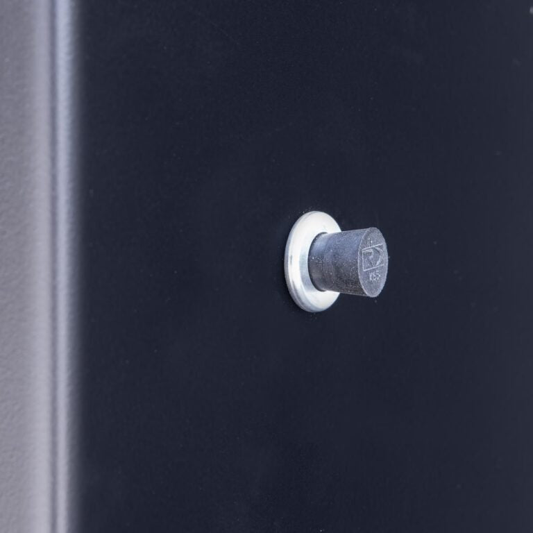 Close-up of the probe port on the Meadow Creek BX25 smoker, showing a small, round metal port set into the black exterior.