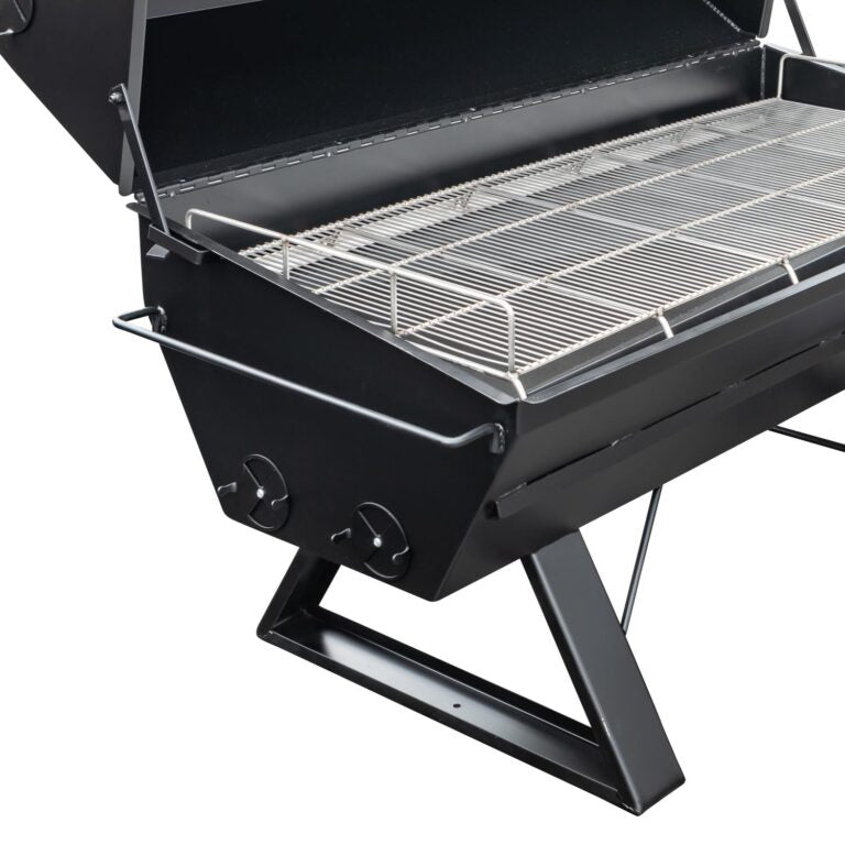 An open, black Meadow Creek pig roaster showing the metal grilling grate and spacious cooking area.