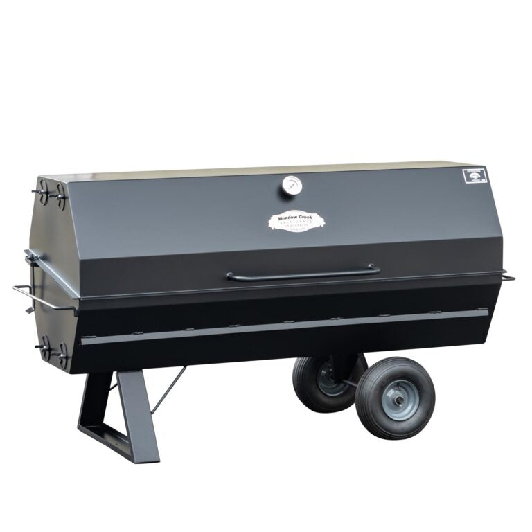 A closed Meadow Creek pig roaster with a black metal exterior, featuring a front handle and two large wheels for easy movement.