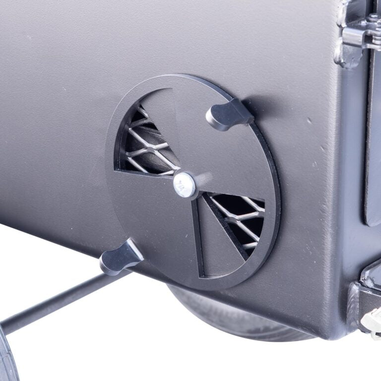 Close-up view of the firebox vent on the Meadow Creek SQ36 smoker, highlighting the adjustable circular vent for controlling airflow.