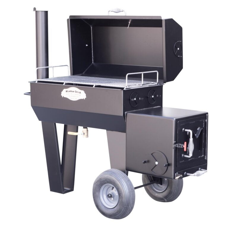 Full side view of a Meadow Creek offset smoker, displaying the main cooking chamber, firebox, and stack vents. The smoker is mounted on large wheels for mobility and has a sleek black finish.