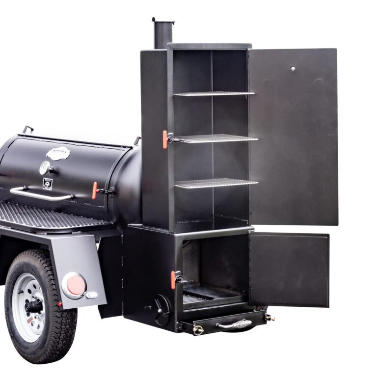 Close-up of the firebox and warming box of a Meadow Creek BBQ smoker trailer, with open doors and visible shelves.