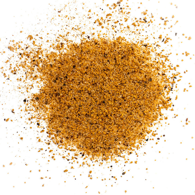 A close-up view of a pile of Meat Church Honey Hog Hot BBQ Rub. The spice mix is a coarse, reddish-brown powder with visible black pepper flakes.