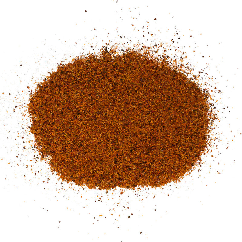 A close-up view of a pile of Meat Church Texas Chili Seasoning. The spice mix is a coarse, dark red powder with a fine, consistent texture.