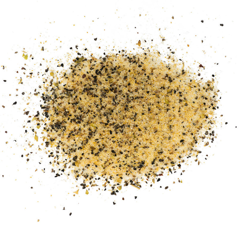 A close-up view of a scattered mixture of Rio Valley Meat Blanco AP Rub seasoning, showing a blend of coarse black pepper, salt, and other spices.