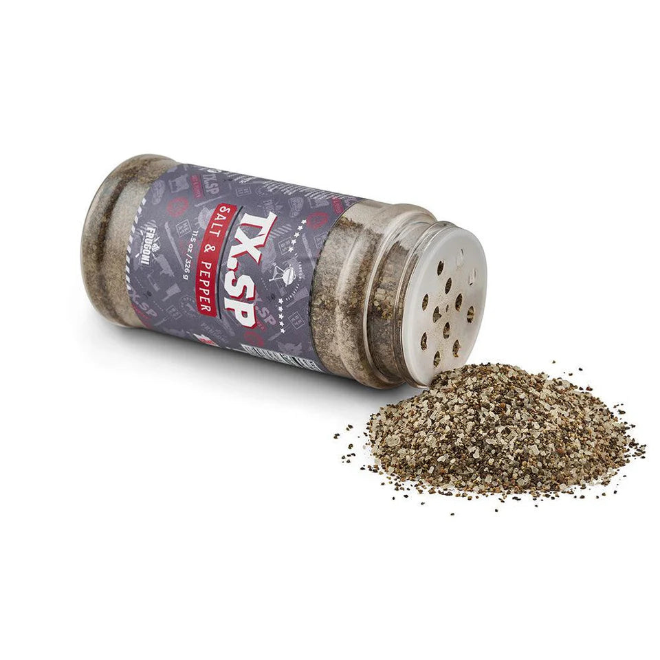 A container of 'TX.SP Salt & Pepper' seasoning lying on its side with some of the salt and pepper mix spilled out onto a white surface.