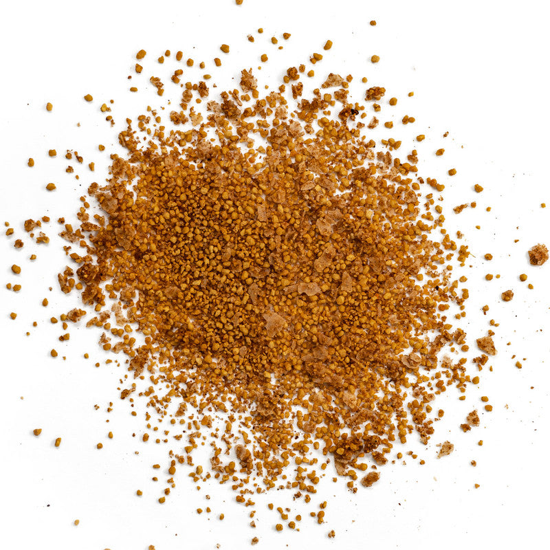 Close-up view of Simply Marvelous Cherry Rub seasoning, showing a pile of reddish-brown granules. The texture appears to be a mix of fine and coarse particles, with visible chunks of seasoning.