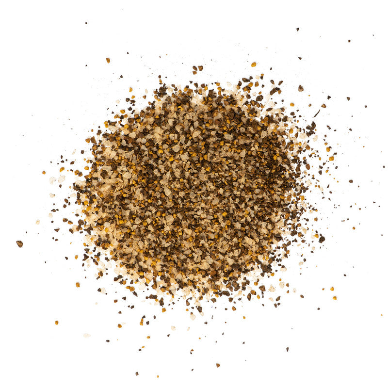 A close-up view of a pile of Tuffy Stone Daily Grind Coffee Rub seasoning, showcasing its coarse, dark brown texture with visible grains of salt and spices.