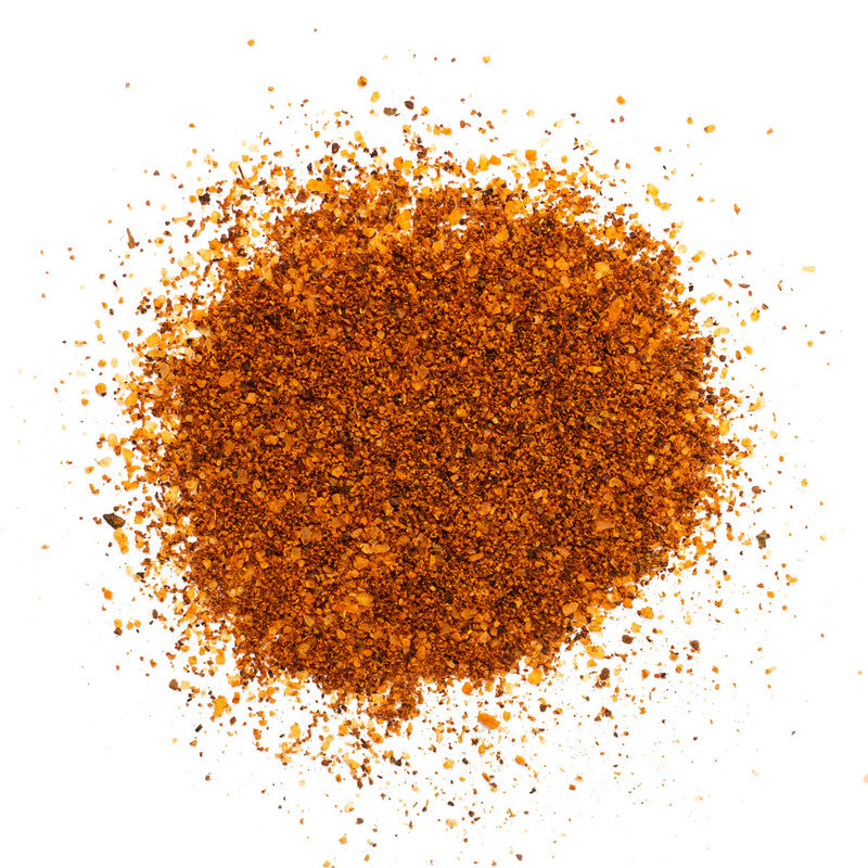  close-up view of a pile of Tuffy Stone Everything Seasoning, showcasing its coarse, orange-brown texture with visible grains of spices.