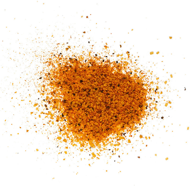 A close-up view of a scattered pile of Tuffy Stone Sweet BBQ Rub on a white background. The rub has a coarse texture with a mix of red and orange spices.