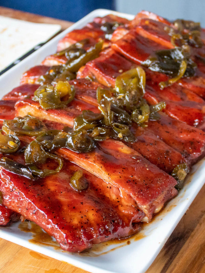 Plate of ribs from Tyson that are sauced with Big Poppa's Granny's BBQ sauce and then topped with jalapenos.