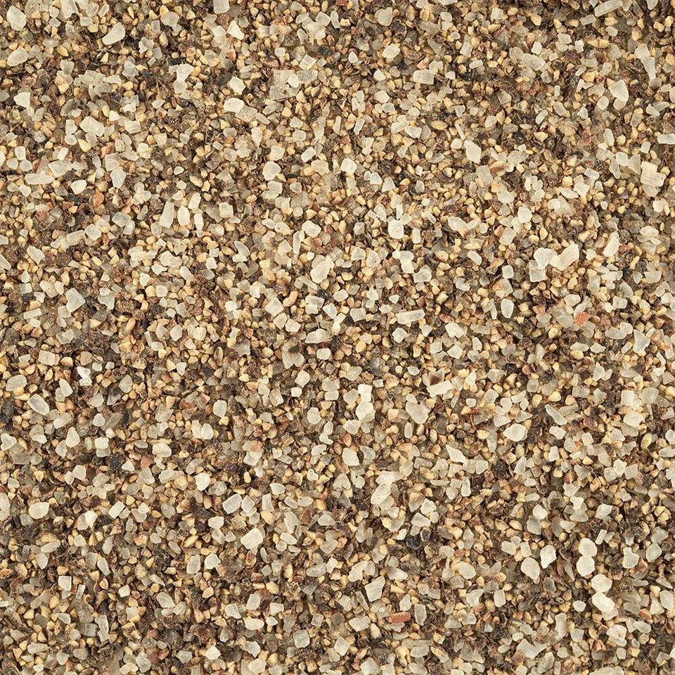 A detailed close-up of a mixture of coarse salt and ground pepper, showing the texture and granules of both spices mixed together.