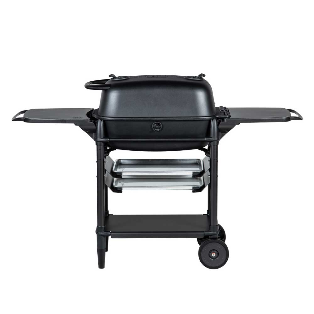 Back view of a PK Franklin charcoal grill with a black lid. The grill includes two side shelves, two trays below the grilling area, and a lower storage shelf. One side of the grill has wheels for mobility.