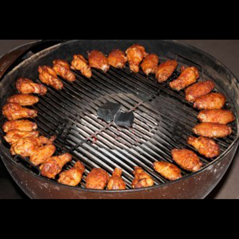 Image of a kettle grill that features the vortex in the middle and chicken wings around the edges of the grill grate.
