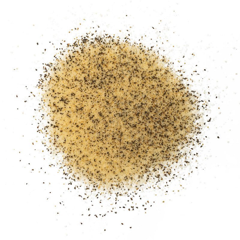 A close-up of Boars Night Out Spicy White Lightning seasoning spread out on a white surface. The seasoning is a coarse blend of white and black particles, likely consisting of salt and various spices.