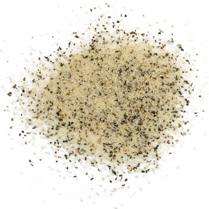 A close-up of Boars Night Out White Lightning seasoning spread out on a white surface. The seasoning is a coarse blend of white and black particles, likely consisting of salt and various spices.
