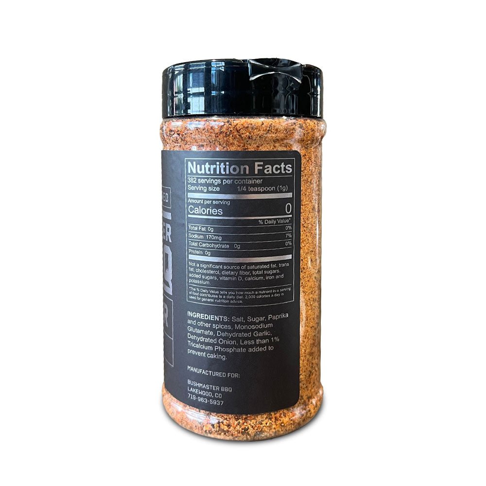 The back view of a 13.5 oz (382g) container of Bushmaster BBQ Brawler Brisket Rub. The label displays nutritional information and ingredients. The serving size is 1/4 teaspoon (1g), with 382 servings per container, and 0 calories per serving. The ingredients include salt, sugar, paprika, other spices, monosodium glutamate, dehydrated garlic, dehydrated onion, and less than 1% tricalcium phosphate. It is manufactured for Bushmaster BBQ, Lakewood, CO, with a contact number 719-963-5937.