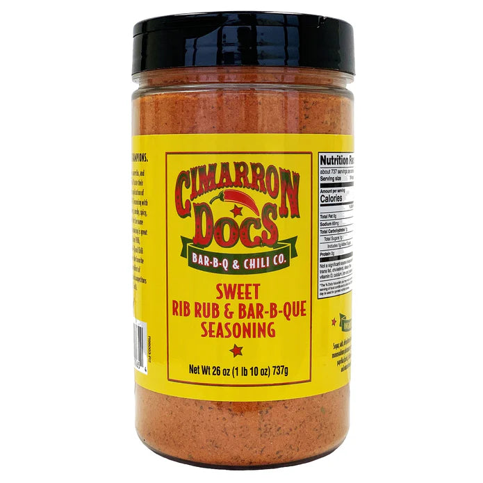 The front of a large jar of Cimarron Doc's Sweet Rib Rub & Bar-B-Q Seasoning with a black lid. The label is yellow with red and green accents and reads 'Cimarron Doc's Bar-B-Q & Chili Co. Sweet Rib Rub & Bar-B-Q Seasoning.' The net weight is 26 ounces (1 lb 10 oz) or 737 grams. Part of the nutrition facts label is visible on the side.